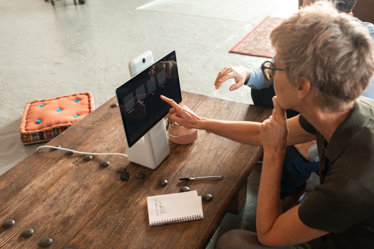 why-choose-us Elderly woman engaged in online learning via a digital tablet indoors.